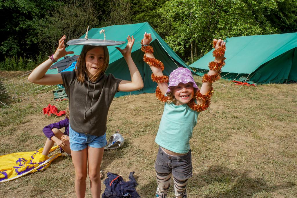 Twee kinderen doen gek met een deksel en een slinger.